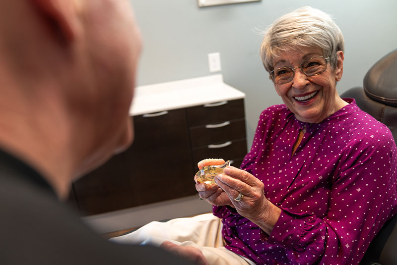 patient holding implant model inside of the dental center