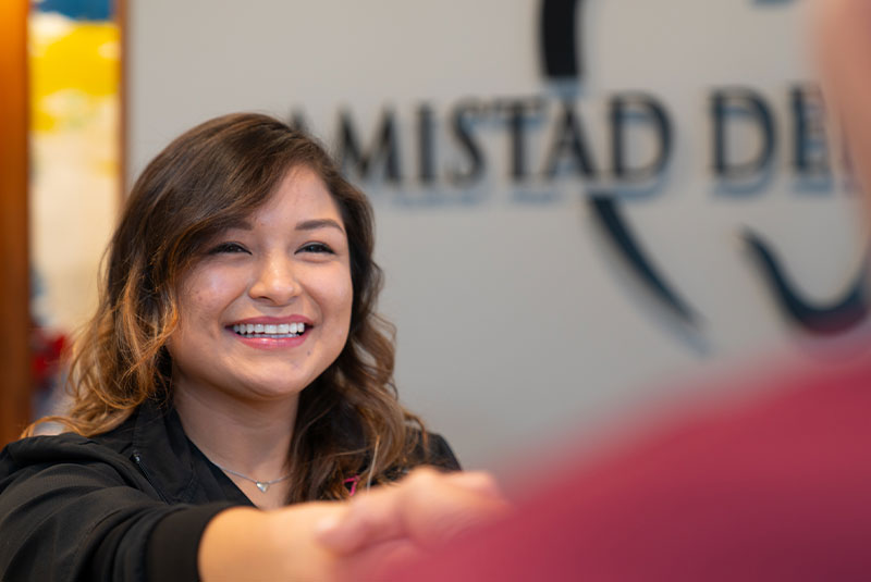 staff member helping patient at the front desk of the dental center